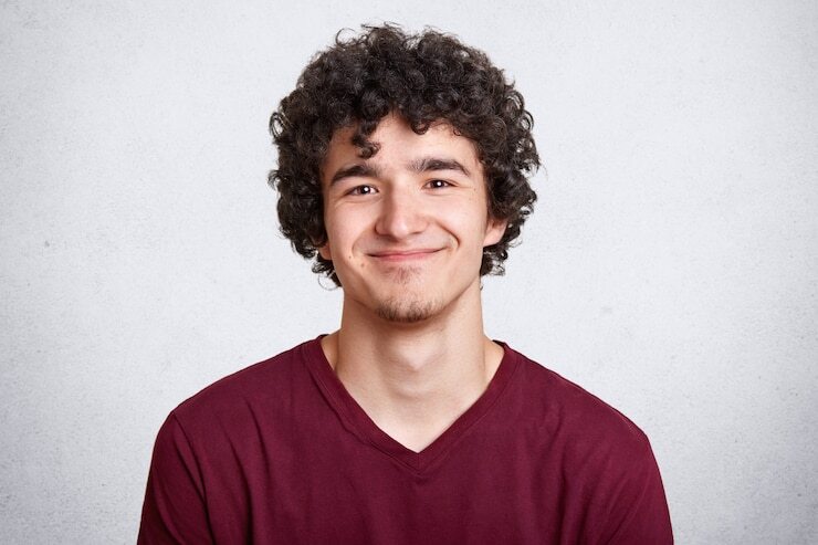 positive-pleased-male-with-curly-hair_176532-8136
